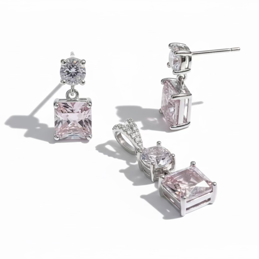 Set of silver jewelry with pink gemstones on a white background