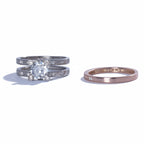Two diamond rings on a reflective surface with a light gray background