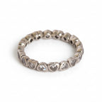 Silver ring with heart-shaped stones on a light gray background