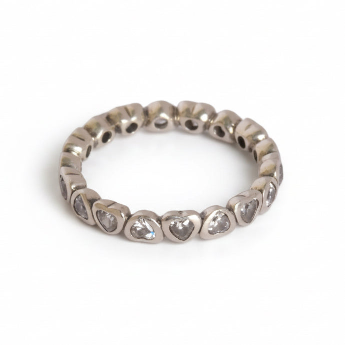 Silver ring with heart-shaped stones on a light gray background