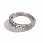 Silver ring with diamond accents on a light gray background