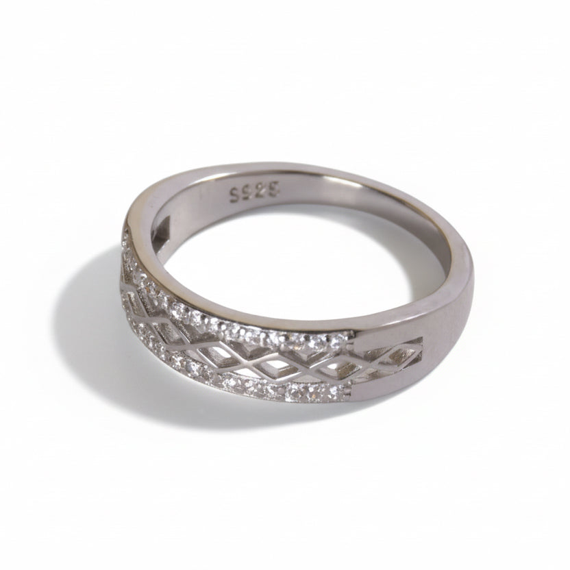 Silver ring with diamond accents on a light gray background