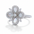 Silver ring with opal stones and diamonds on a light gray background