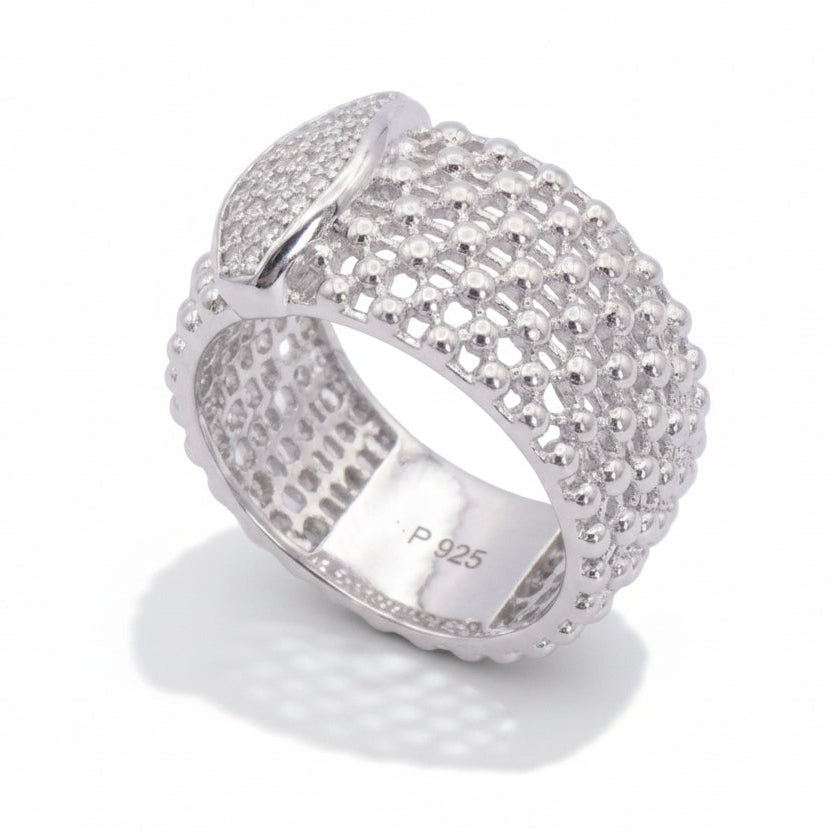 Silver ring with intricate design on a light gray background