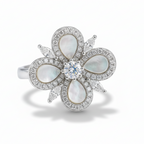 Elegant ring with floral design featuring pearls and a diamond on a light gray background