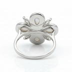 Silver ring with pearl-like stones on a white background