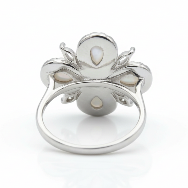 Silver ring with pearl-like stones on a white background