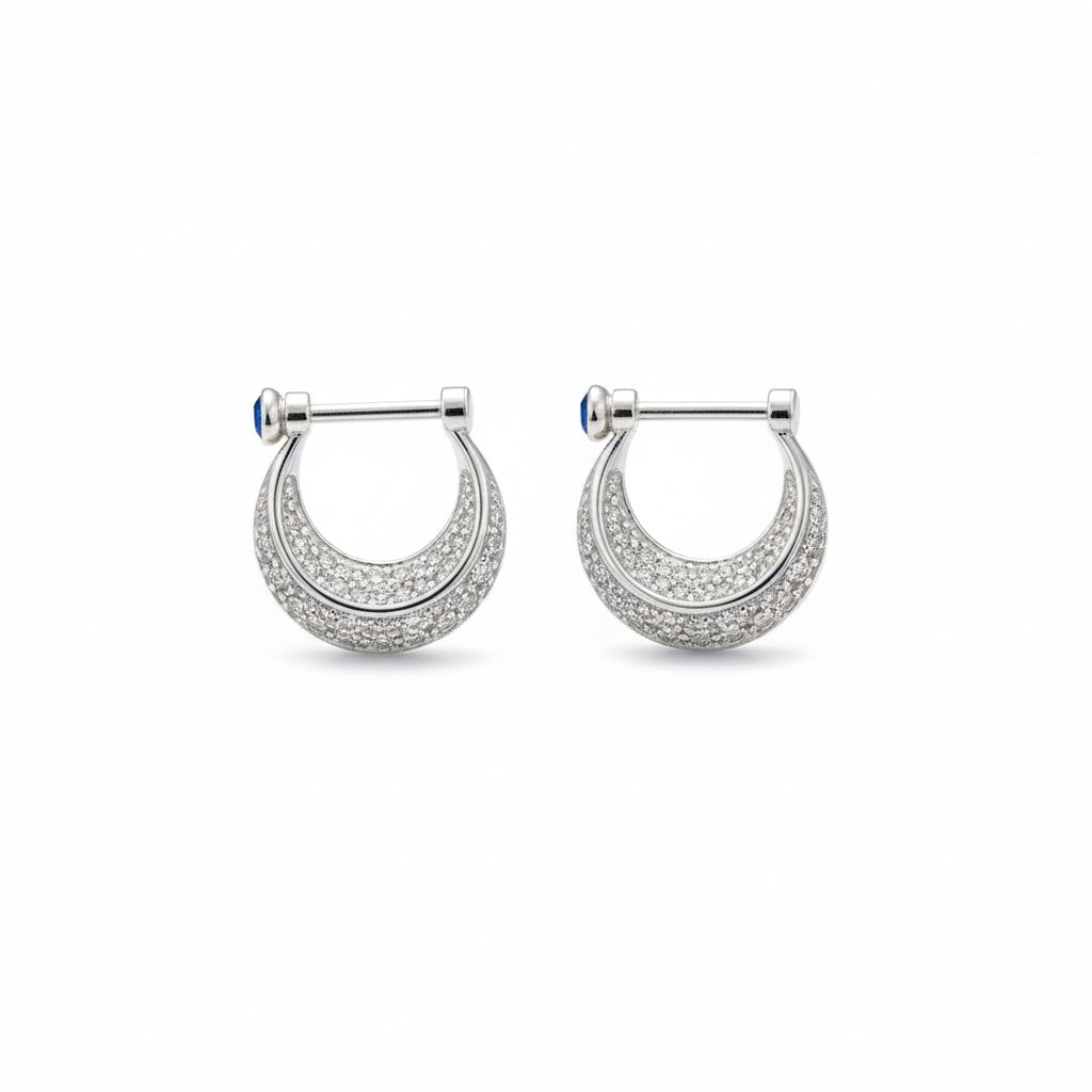 Silver earring with a blue gemstone on a white background