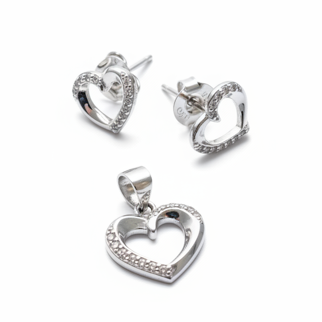 Silver heart-shaped earrings and pendant on a white background