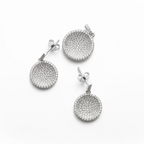 Pair of silver earrings and pendant  with circular designs on a white background