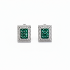 Pair of emerald green gemstone earrings with silver frames on a white background