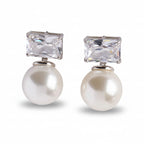 Pair of earrings with pearl drops and crystal tops on a light gray background
