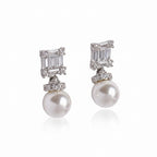 Pair of pearl and diamond earrings on a light gray background