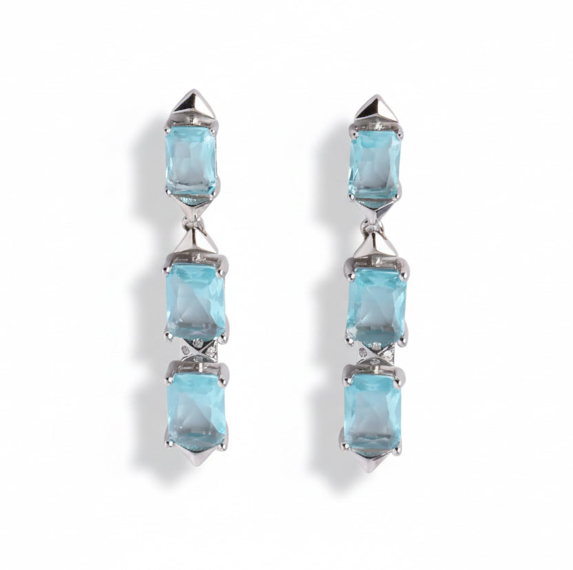 Pair of earrings with blue gemstones on a white background