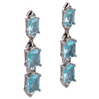 Pair of earrings with blue gemstones on a light gray background