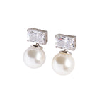 Pair of earrings with crystal and pearl design on a light gray background