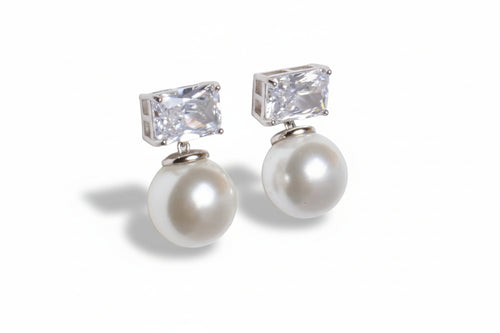 Pearl and crystal earrings on a light gray background