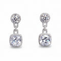 Pair of silver earrings with clear gemstones on a light gray background