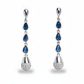 Pair of silver earrings with blue gemstones on a white background