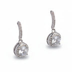 Pair of silver earrings with clear gemstones on a light gray background
