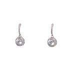 Pair of silver earrings with clear gemstones on a light gray background
