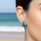 Butterfly-shaped earrings with blue and silver design on a white background