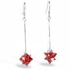 Red geometric earrings on a white background