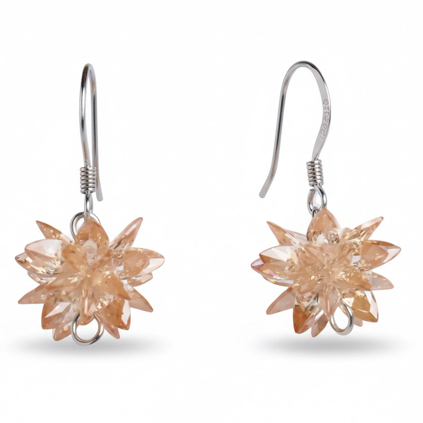 Pair of star-shaped earrings with a peach-colored gemstone on a white background