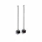 Pair of earrings with black cube-shaped drops on a white background