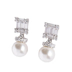 Pair of pearl earrings with silver accents on a light gray background