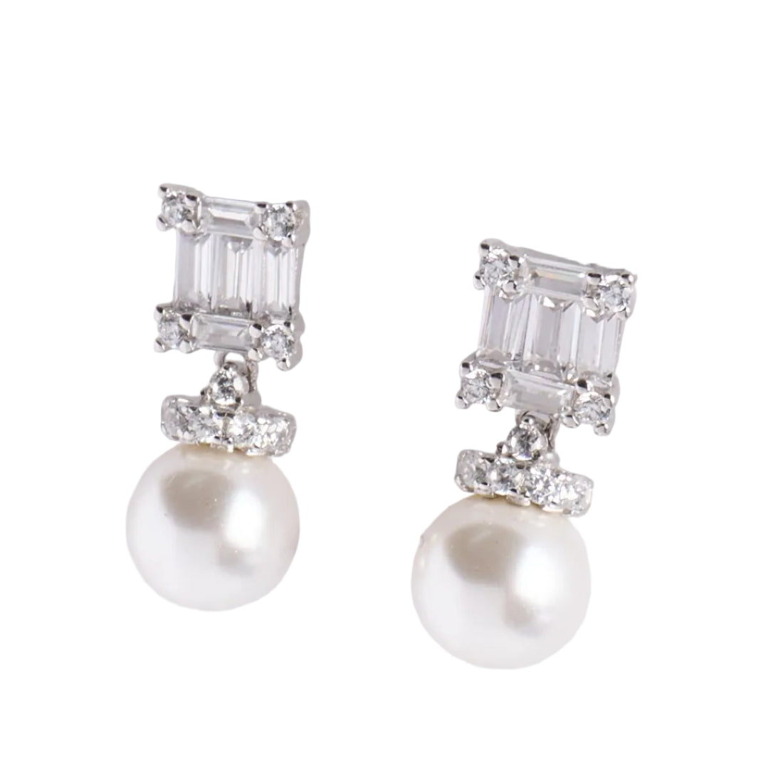 Pair of pearl earrings with silver accents on a light gray background