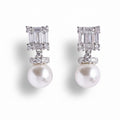 Pair of pearl earrings with diamond-like stones on a white background