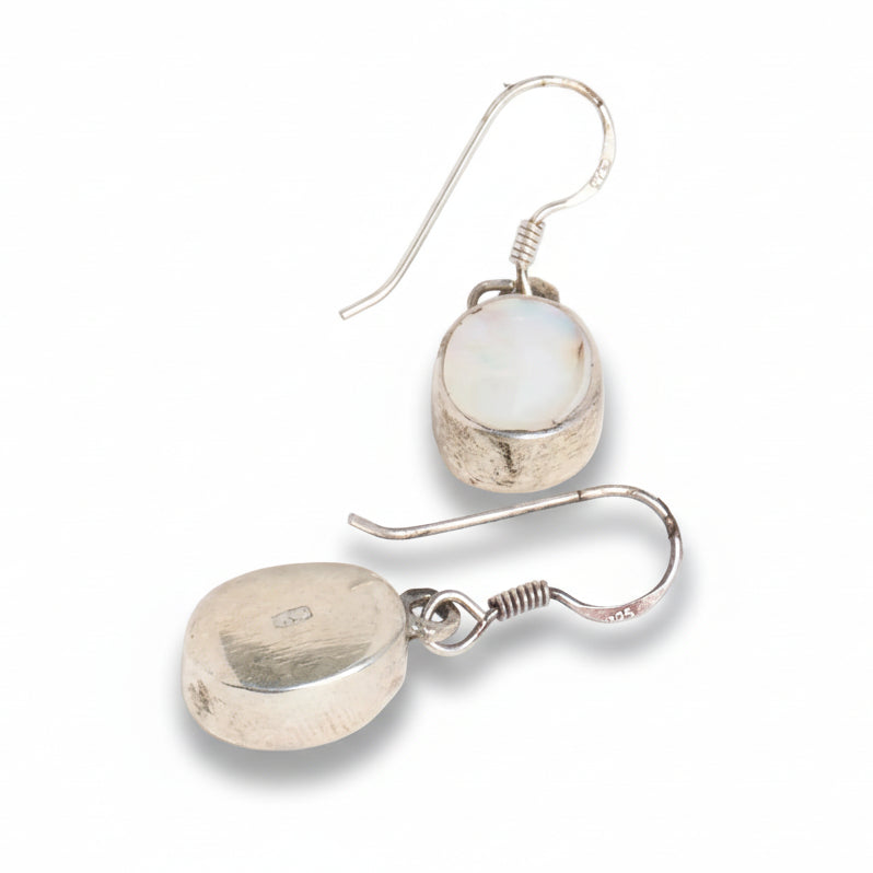 Pair of silver earrings with round, light-colored gemstones on a white background