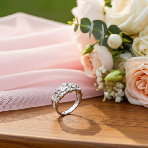 Silver ring with diamonds on a wooden surface with pink fabric and flowers in the background