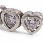 Silver heart-shaped earrings with clear gemstones on a white background