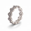 Silver ring with floral designs on a light gray background