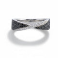 Silver ring with black and white gemstones on a light gray background