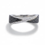 Silver ring with black and white gemstones on a light gray background