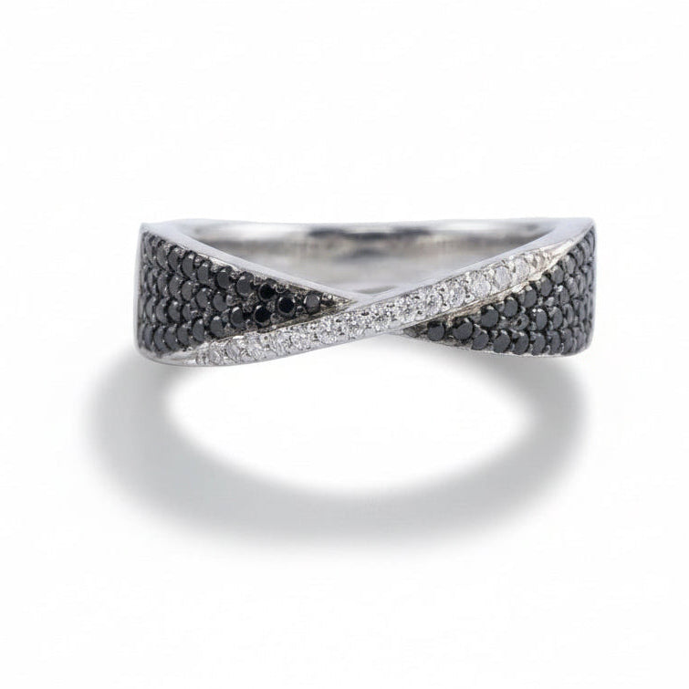 Silver ring with black and white gemstones on a light gray background