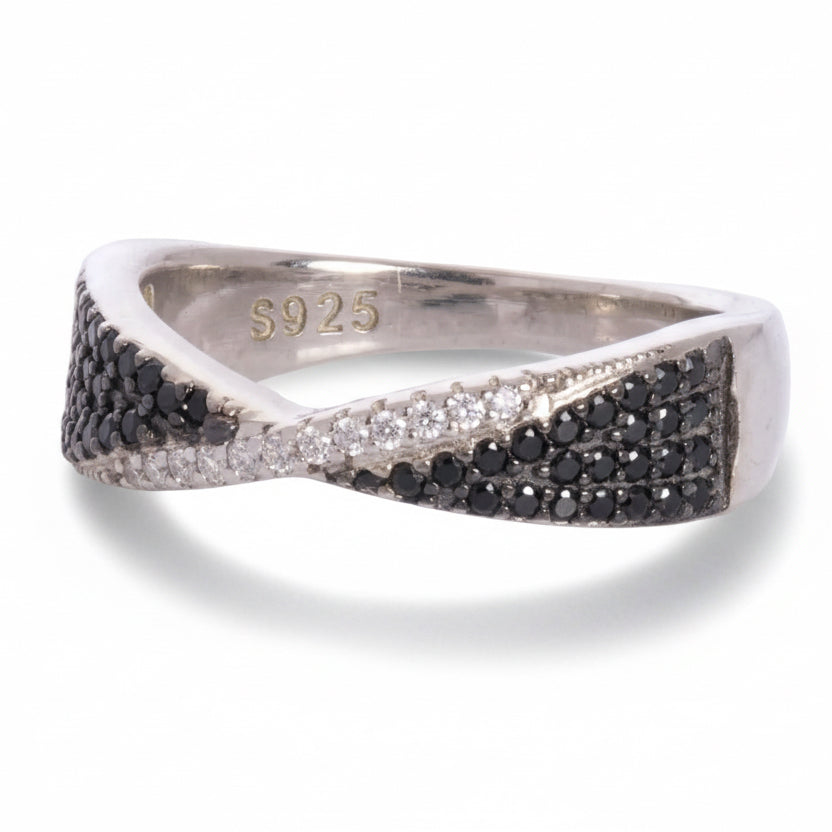 Silver ring with black and white gemstones on a white background