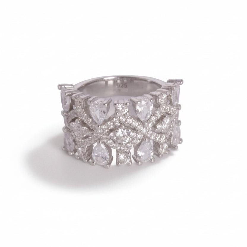 Silver ring with diamond-like stones on a light gray background